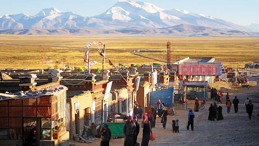 Reisende reisen an der geschäftigen Stadt Darchen in Tibet vorbei